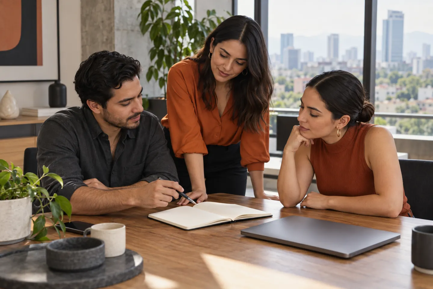 Equipo comercial revisando el reparto de trabajo alrededor de un cuaderno.
